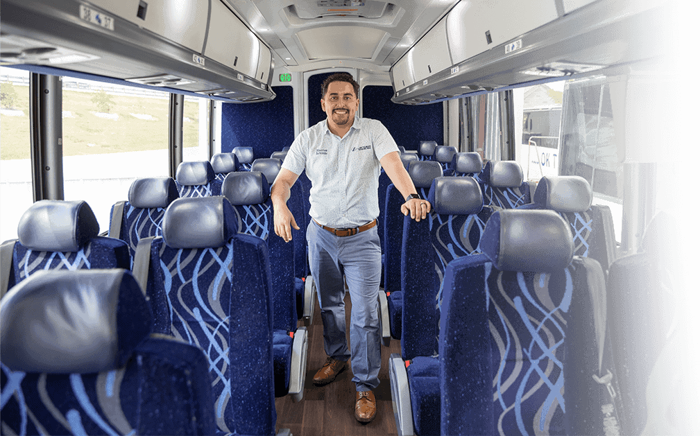 A man standing in the middle of an empty bus.