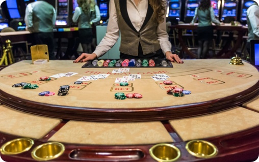 A woman is standing at a casino table with chips.