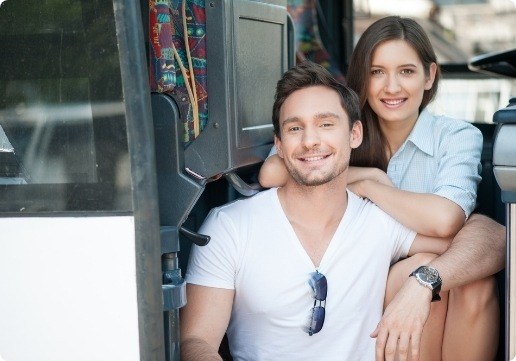 A man and woman sitting in the back of a bus.