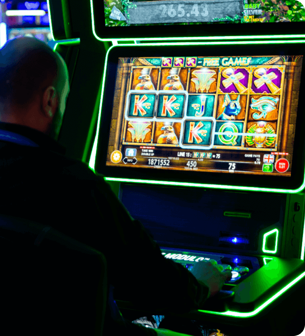 A man playing a slot machine in a casino.