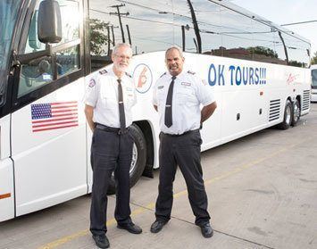 Two men standing in front of a bus.