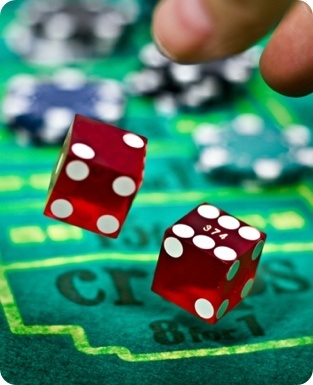 A person is throwing dice on a casino table.