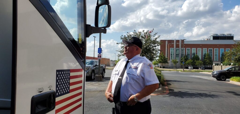 A police officer standing in front of a bus.
