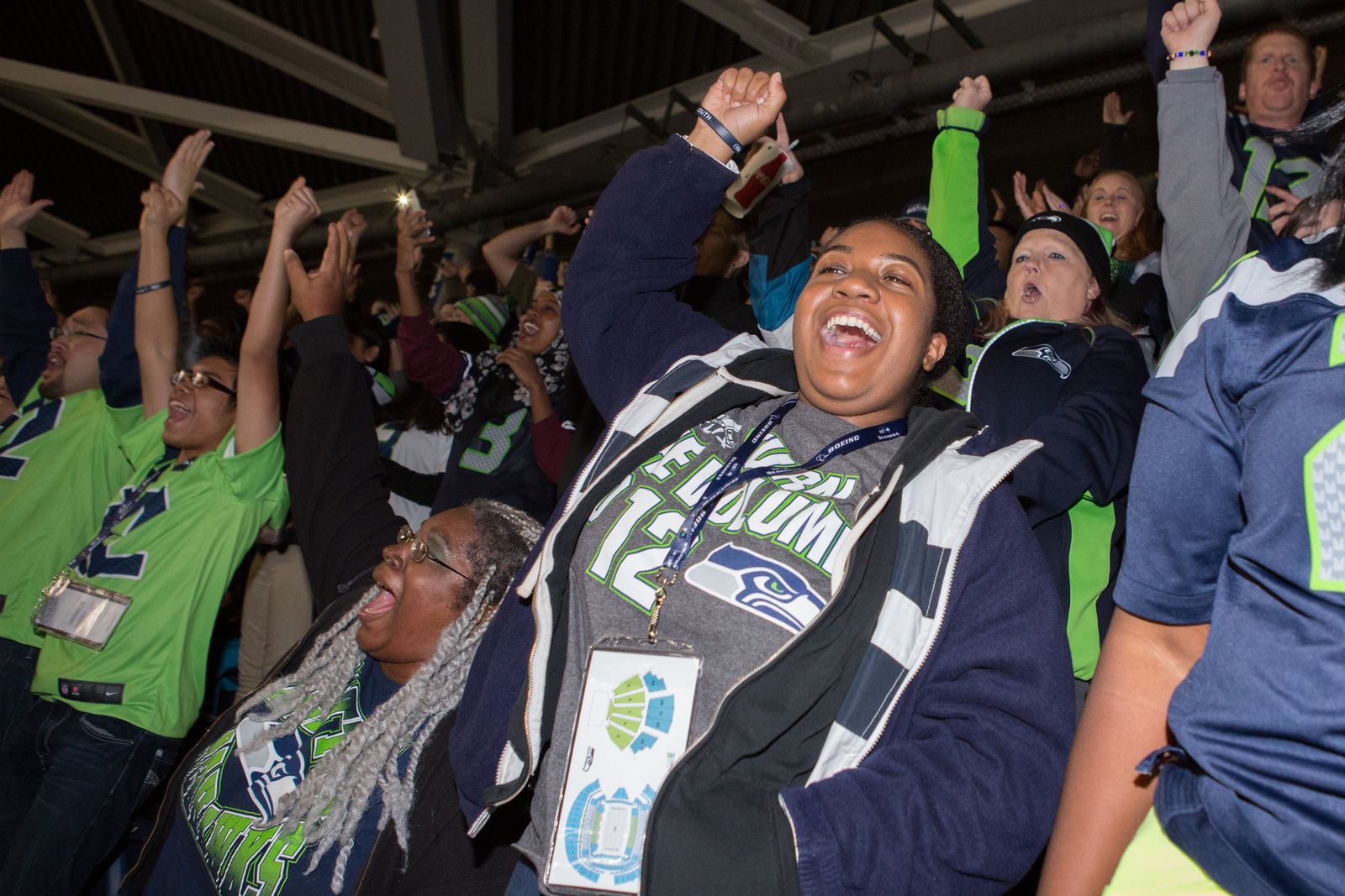 A group of seattle seahawks fans cheering in the stands.