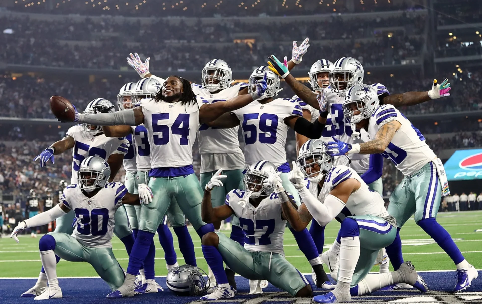The dallas cowboys are celebrating on the field.