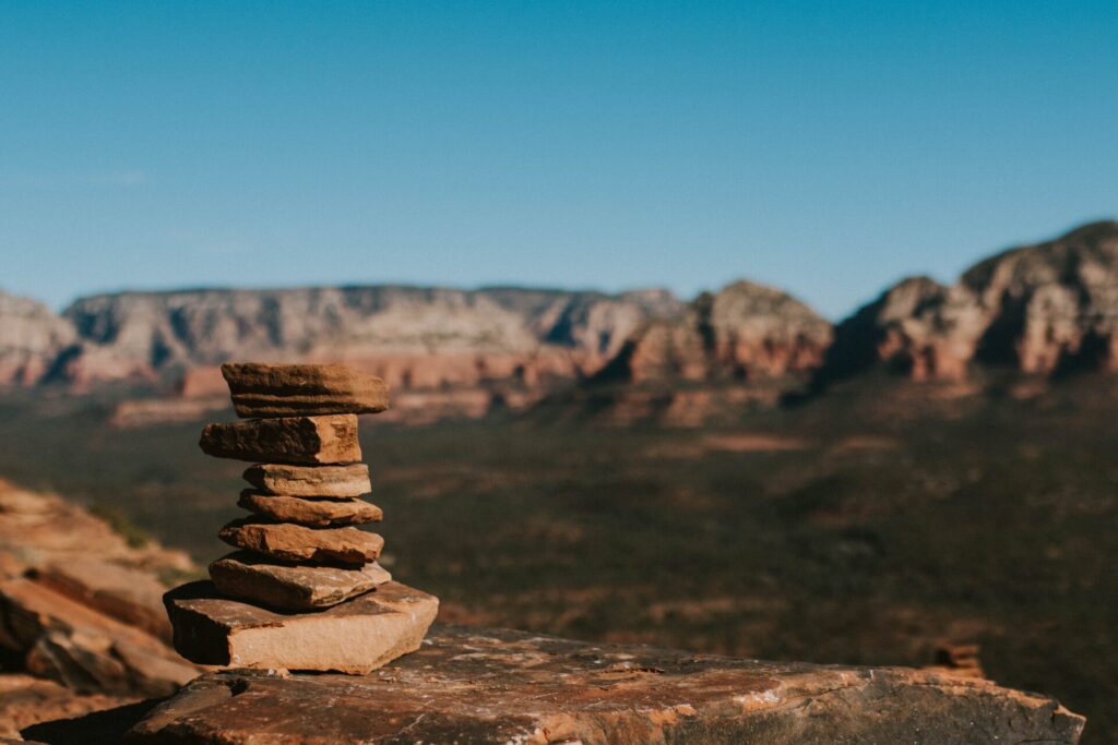 ian-mackey-gZxGRJfq1Ko-unsplash A stack of rocks on top of a mountain in sedona, arizona.