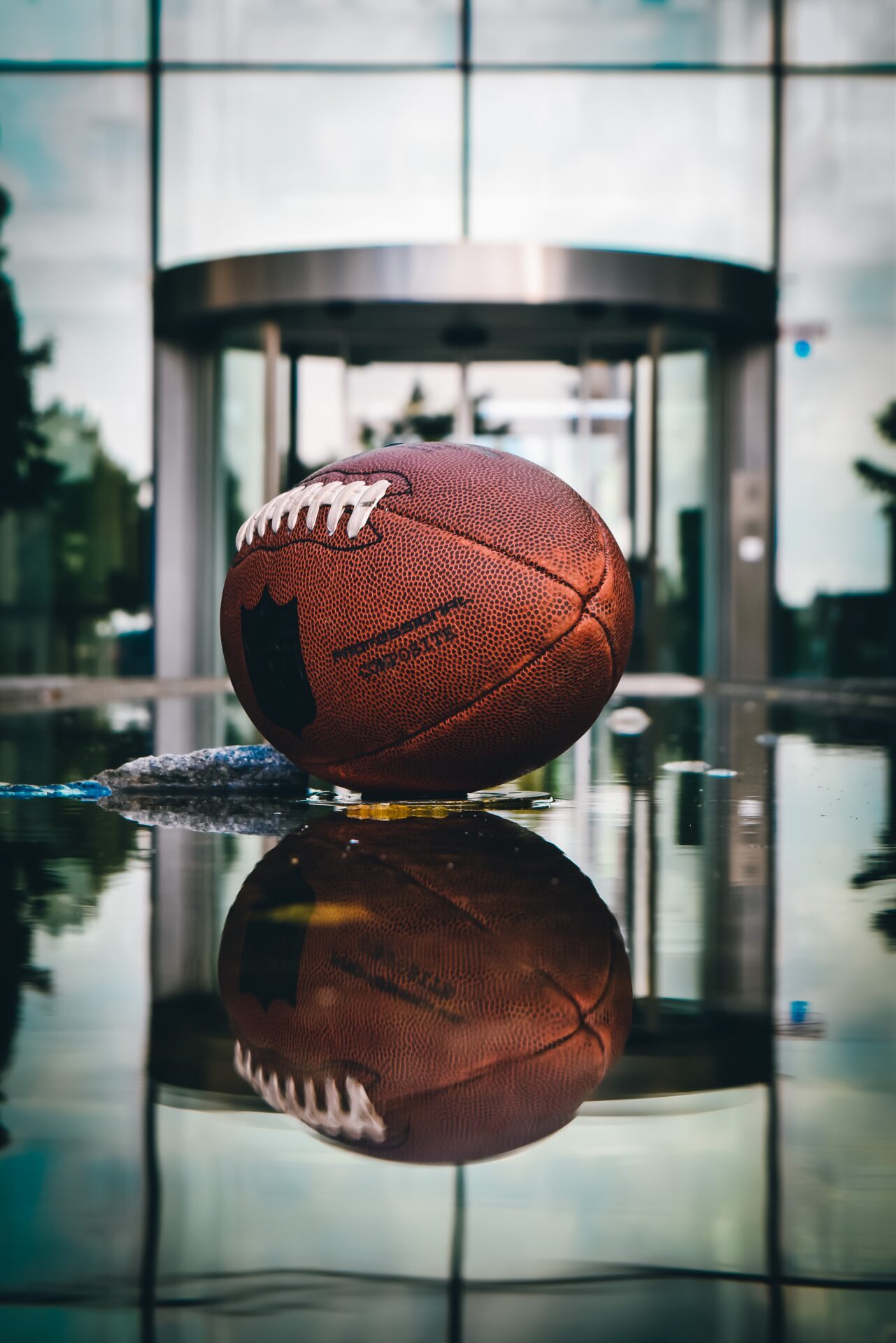 A football sits on a table in front of a building.